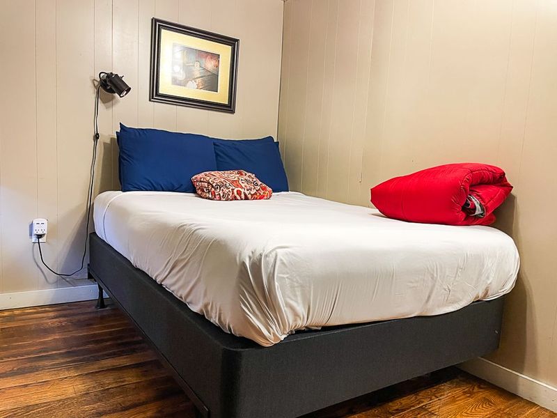 Bedroom with a neatly made bed and red accent pillow