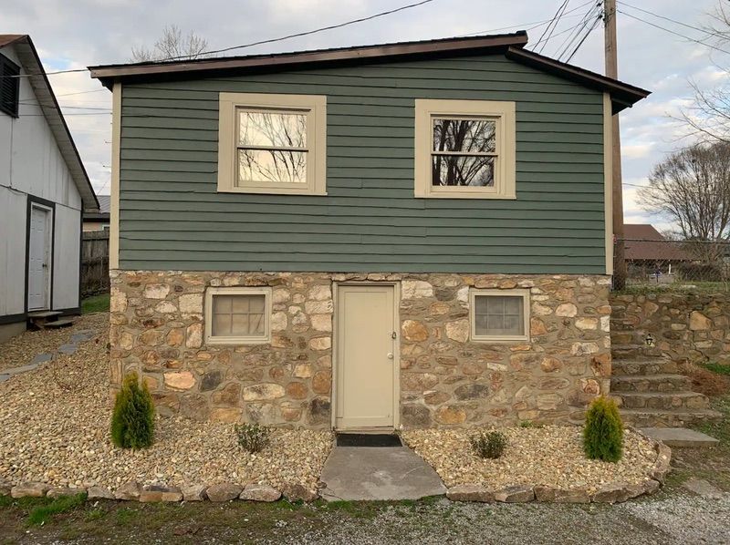 Efficiency cottage exterior with stone foundation and covered porch